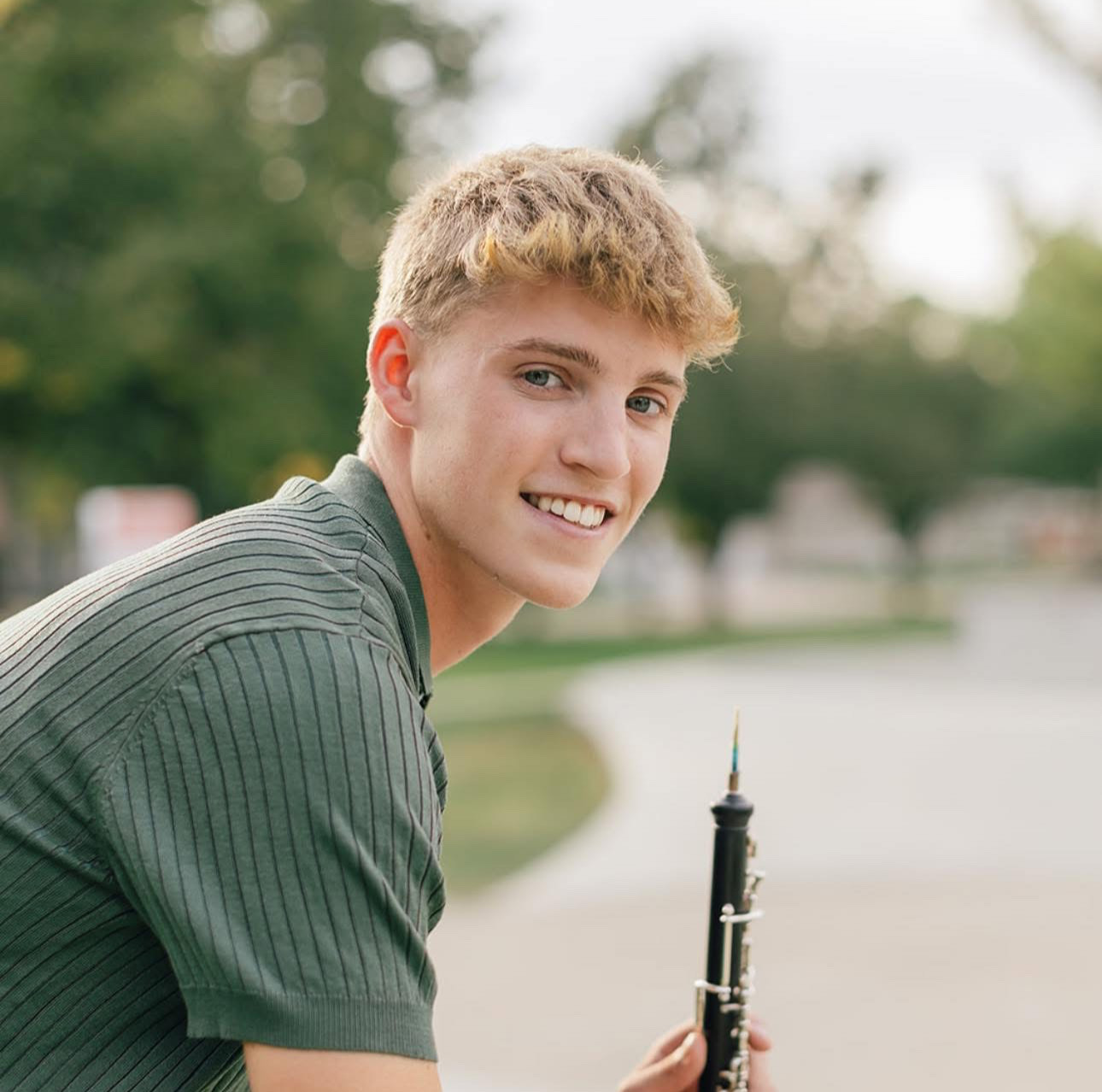 Blake Daale sitting, holding an oboe in front of him