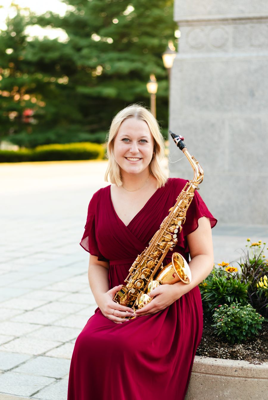 Hannah sitting outside, holding a saxophone