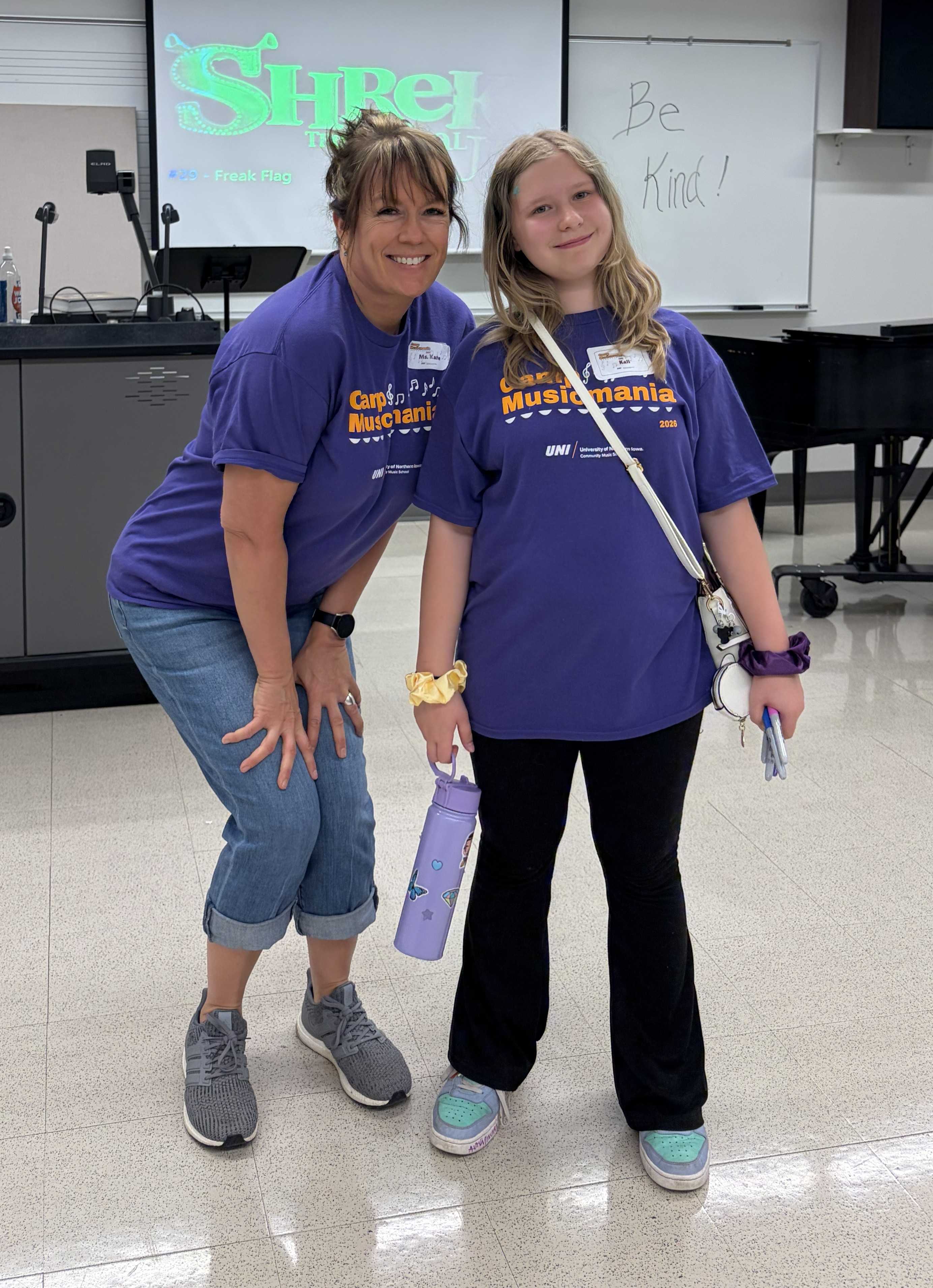 Kate Saulsbury posing with young female student, smiling at the camera.