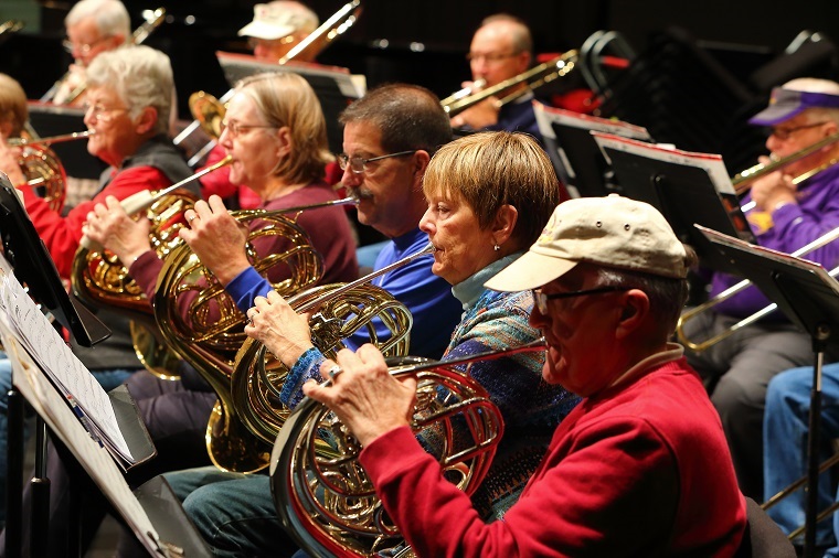 members of the horn section of the new horizons band playing in rehearsal
