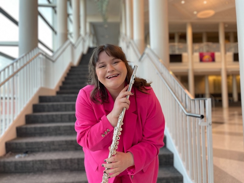 Emily Paul standing with flute, smiling