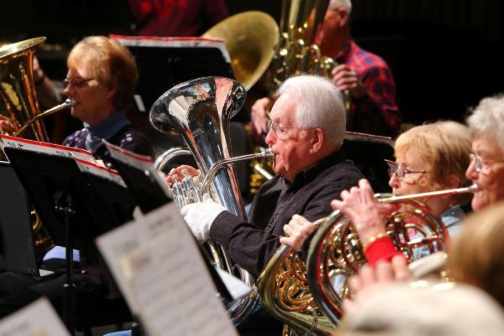 View of brass section playing during rehearsal.