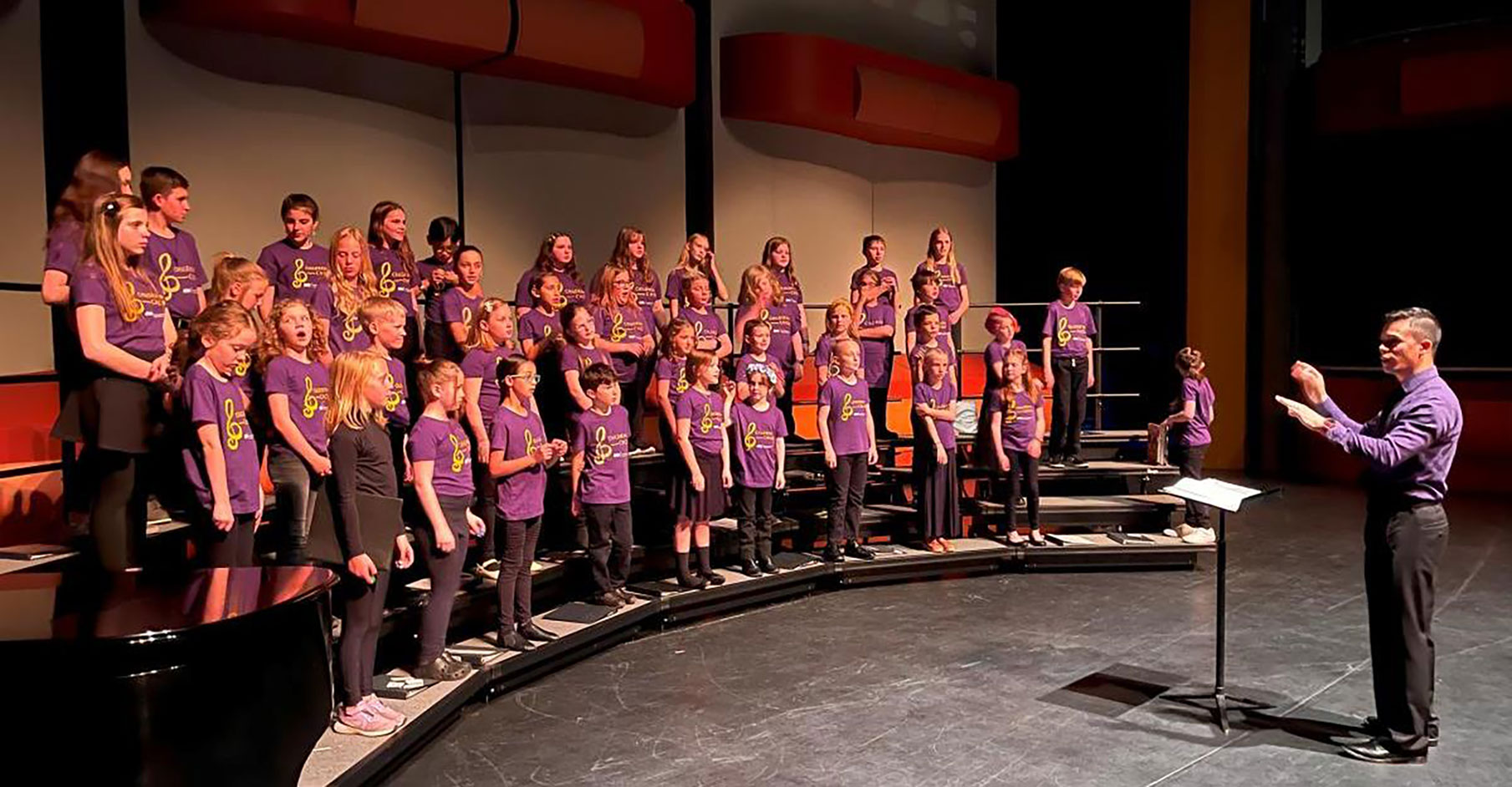 Children choir on stage performing.