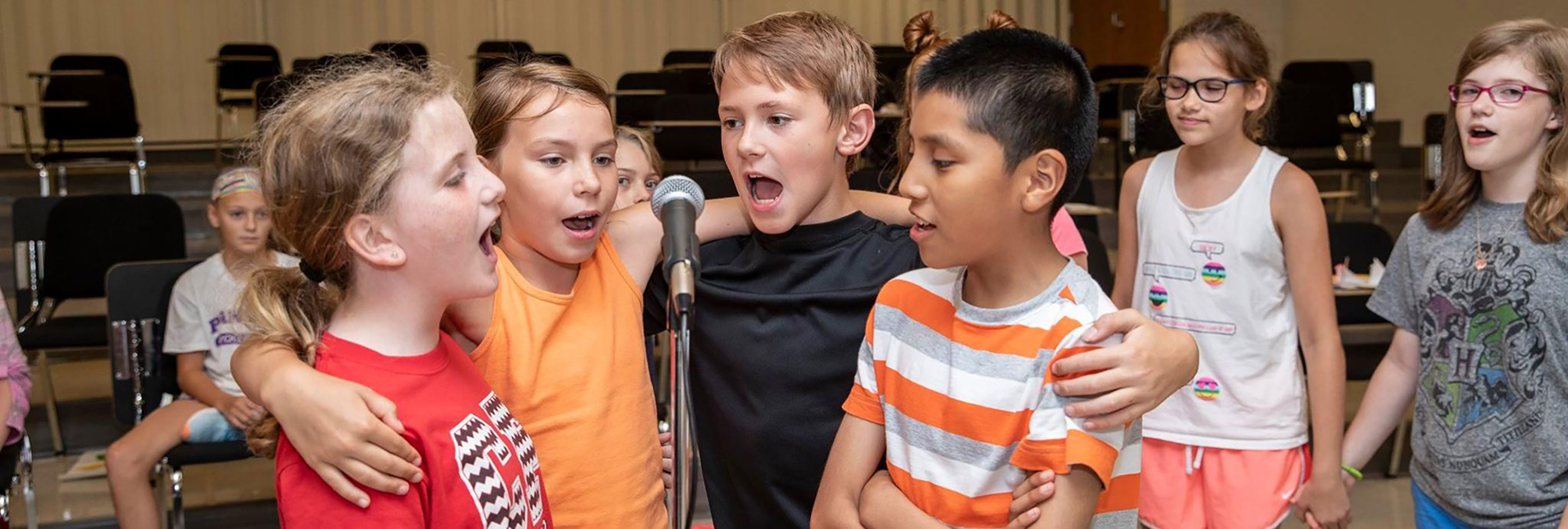 Children singing into a microphone.
