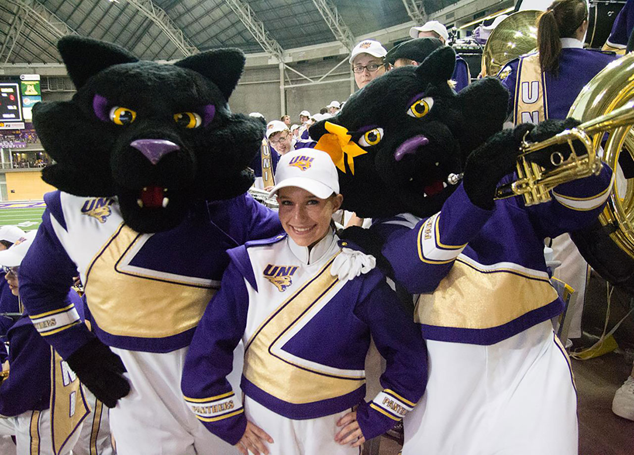 Student posing with TC and TK UNI mascots.
