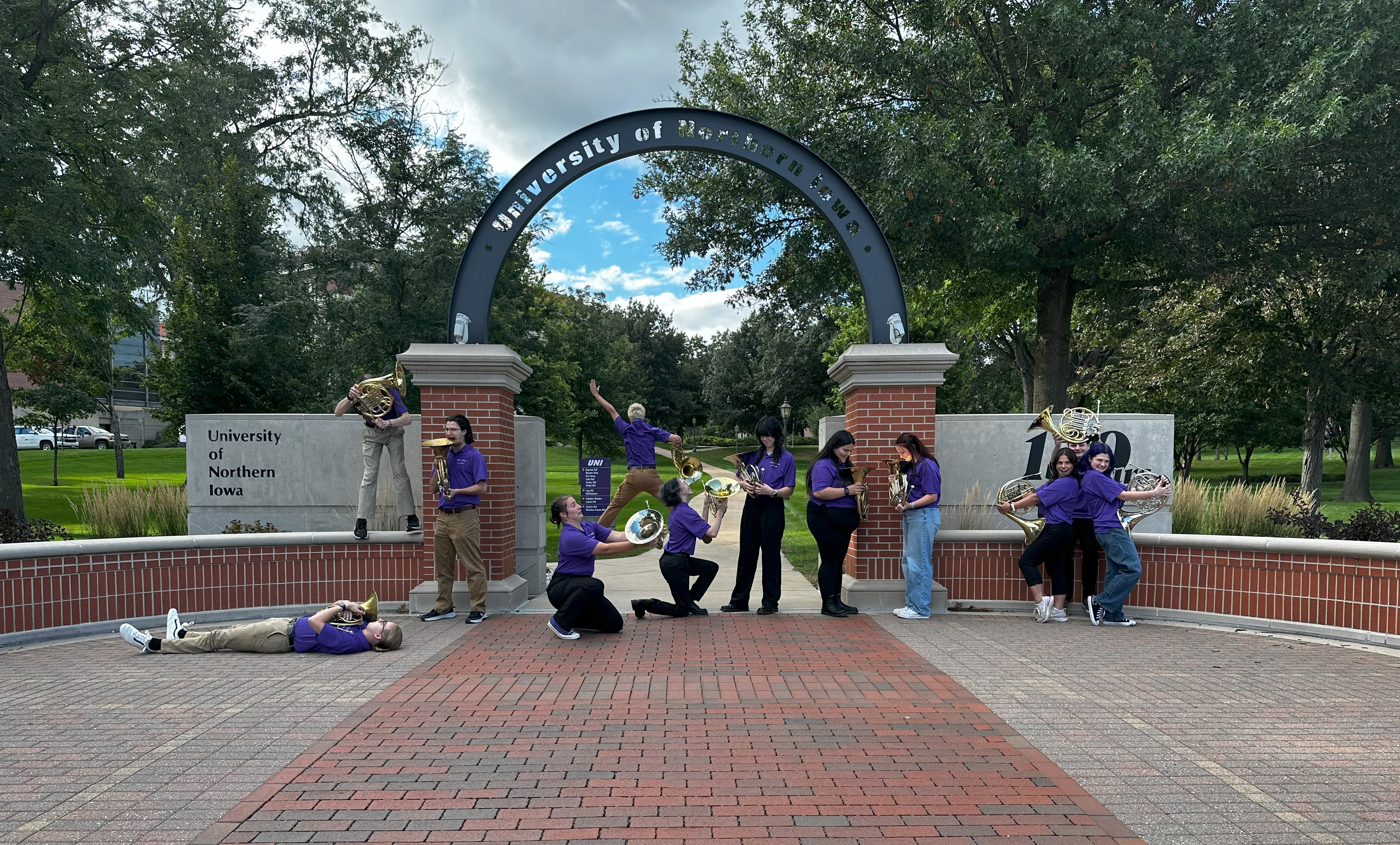 students pose in response to "chaos" in a funny way under UNI arch