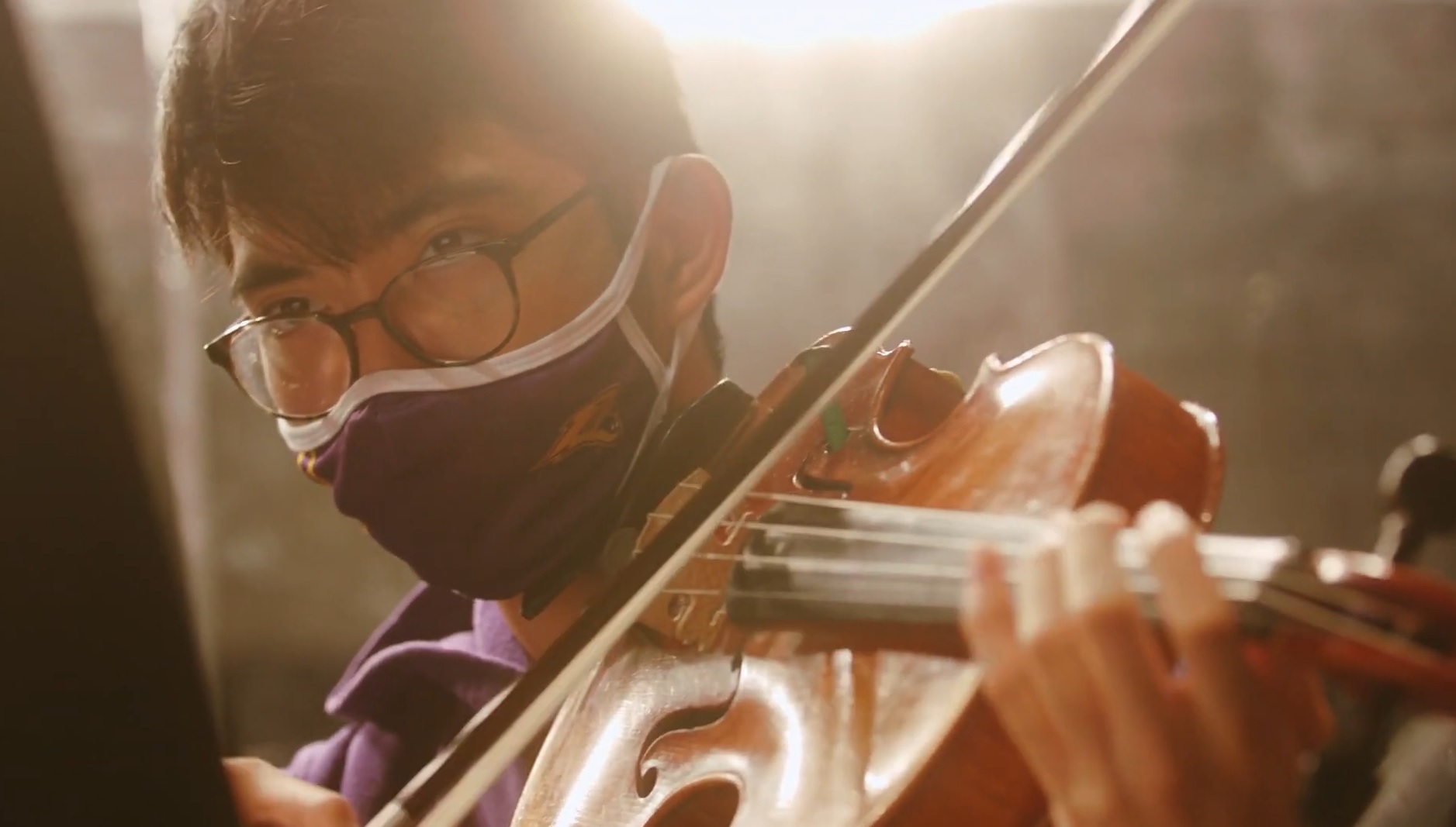 a masked student plays a violin