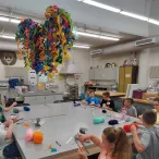 Kids sitting at a table working on yarn projects