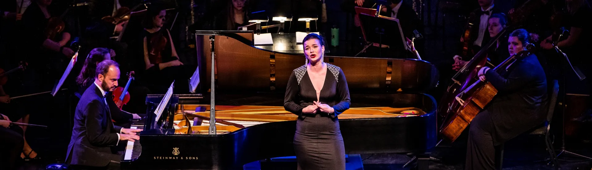 Opera singer performing on stage with pianist